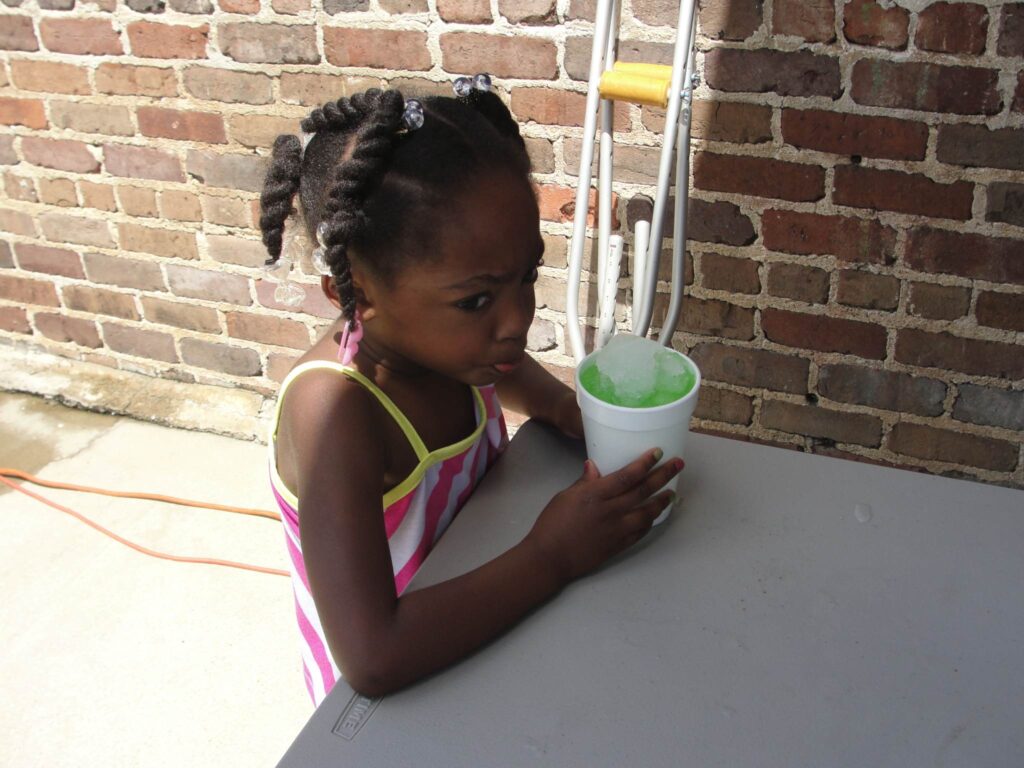 a little girl sitting in front of a building