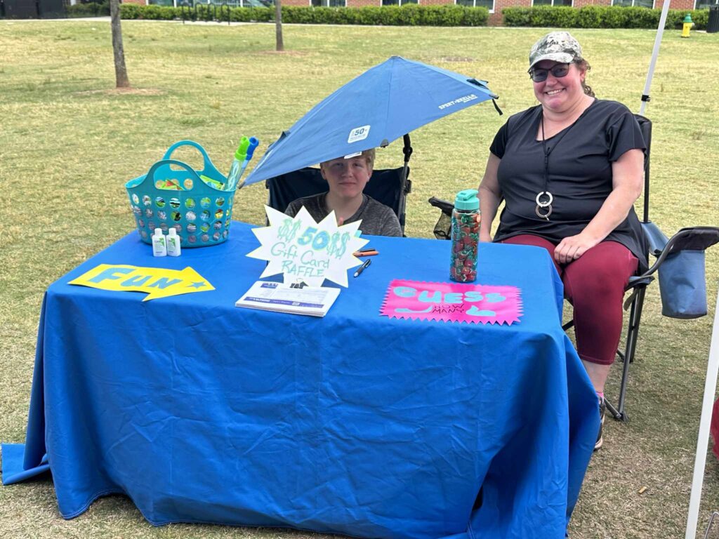 a man sitting at a table with a blue umbrella