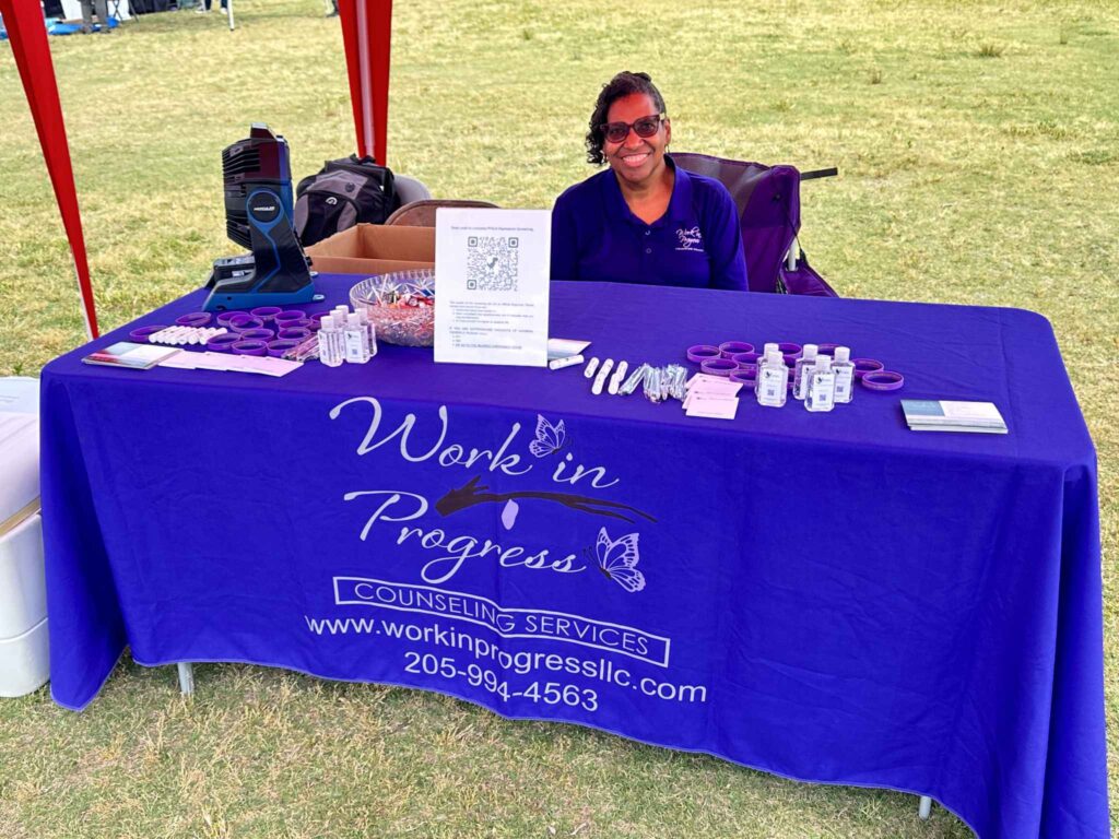 a person sitting at a table with a purple sign