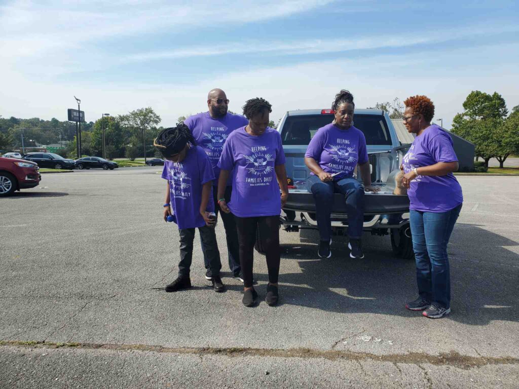 a group of people standing in a parking lot